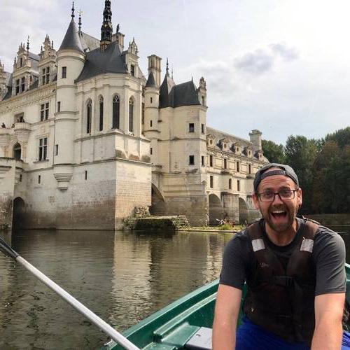 Nicholas Norris in a boat in front of a castle